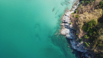 Aerial view. Top view of turquoise sea water washes the rocky shore in Thailand. Landscape background