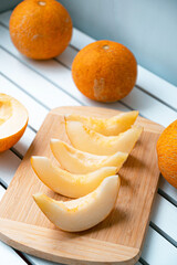 Vertical photo of ripe melon and melon slices on wooden board