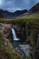Fototapeta na wymiar A waterfall in the Fairy Pools on the Isle of Skye under a stormy sky, Scotland, United Kingdom