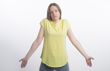 It's not a big deal. Clueless young woman dressed in casual clothing shrugging shoulders and...