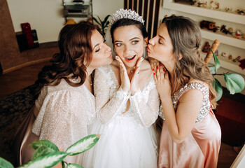 Emotional bride with bridesmaid posing in the room. Morning of the bride.