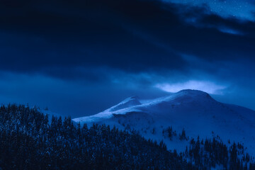 Mountain peak covered with snow in a moonlight
