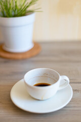 Dirty cup of coffee on a wooden countertop in the kitchen. Morning breakfast concept. Vertical photo
