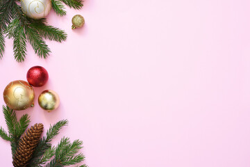Beautiful Christmas composition on a red background with fir. Pink background with fir, christmas balls and decor. Top view with space for copy.