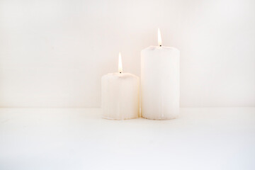 Fototapeta na wymiar two white candles with fire on white background