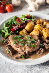 Pork loin chop with mushroom sauce and baked potatoes