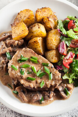 Pork loin chop with mushroom sauce and baked potatoes
