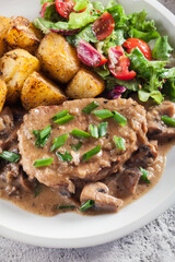 Pork loin chop with mushroom sauce and baked potatoes
