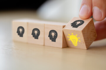 creative idea concept. hand man flip wooden block cube form human idea mark symbol to right light bulb symbol. vintage style