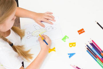 girl is sitting at the table in class writing drawing