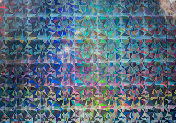 macro photo of silver rainbow holographic foil, colorful hologram surface, glitter grid pattern...