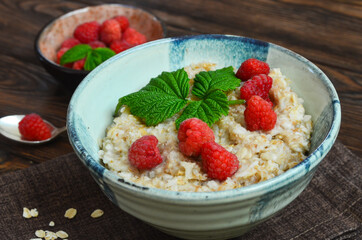 Delicious oatmeal porridge with ripe raspberries. Healthy and hearty Breakfast. The concept of diet and vegetarian food for a slim figure lifestyle