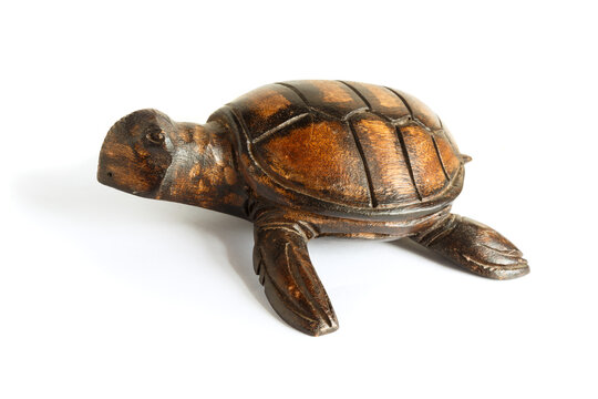 Wooden figurine of a sea turtle on a white background.
