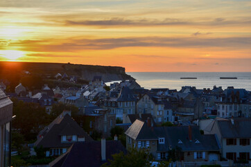 The town of Arromanches-les-Bains in Normandy on the coast of the English Channel at sunset,...