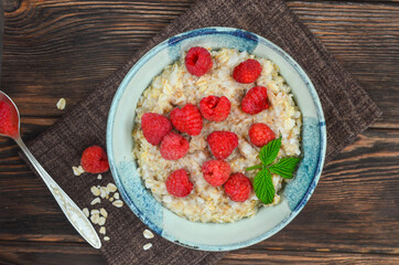 Delicious oatmeal porridge with ripe raspberries. Healthy and hearty Breakfast. The concept of diet and vegetarian food for a slim figure lifestyle