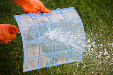 Asian man cleaning air conditioner dirty filter