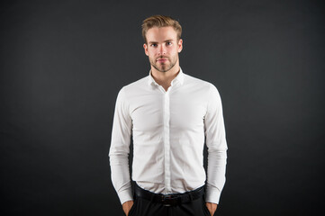 Fototapeta premium Serious handsome unshaven guy in formal style with fashion look grey background, man