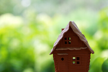 Selective focus on a miniature house on a blurred natural background.