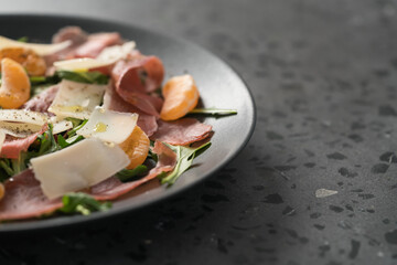 Salad with prosciutto, tangerines and vintage cheese with copy space