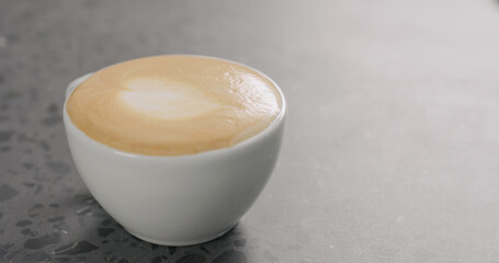 cappuccino in white cup on concrete background