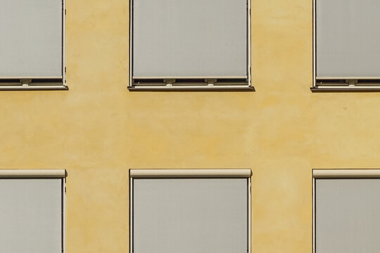 Close-up shot of Windows and Blinds.  Ochre Painted Facade Detail. Minimal Aesthetics.