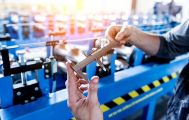 Male hands hold vernier caliper and measure steel collar.
