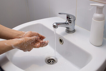 Coronavirus pandemic prevention wash hands with soap warm water and , rubbing nails and fingers washing frequently or using hand sanitizer gel.