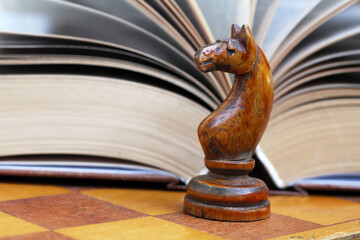 Wooden figure of a horse chess and a book background, retro object