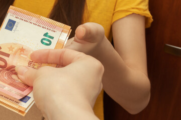 cash delivery in euros. Female hand transfers money to the courier with the order