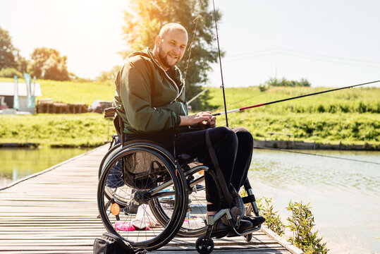 Young Disabled Man In A Wheelchair Fishing.