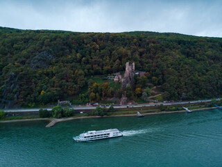 Obraz premium Castle in the forest on the shore. The river Rhine and a ship floating on it. Aerial photo.
