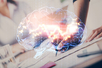 Double exposure of woman's writing hand on background with brain hud. Concept of learning.