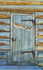door is locked in an old wooden hut. iron lock, old rusty door hinges