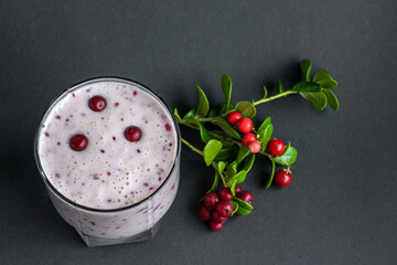 Berry smoothie. Milkshake with fresh lingonberries on a dark background. Healthy food, detox or...