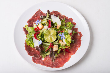 Beef Carpaccio with salad and lime on top