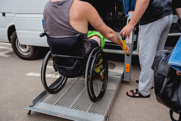 Obraz premium Disabled man on wheelchair using accessible vehicle with lift mechanism.