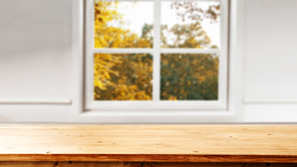 Blurred autumn window background and desk fo free space for your decoration 