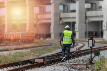 young man on railway.engineer walking and check track work on railways. people  walk on railway .