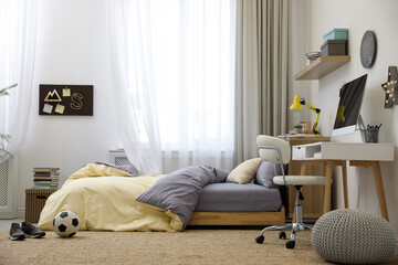 Stylish teenager's room interior with comfortable bed and workplace