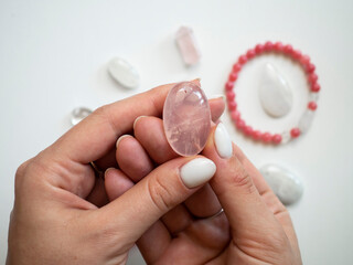 Natural pendant of rose quartz in a woman's hand