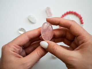 Natural pendant of rose quartz in a woman's hand