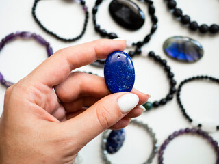 Pendant made of natural lapis lazuli in a woman's hand