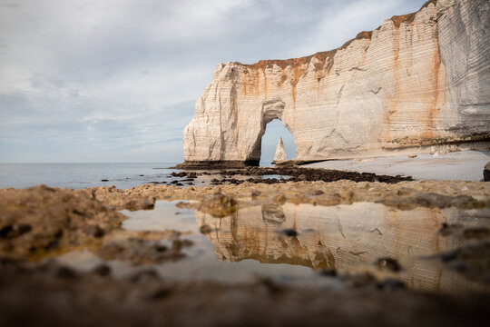 Manneporte d'Etretat et l'Aiguille se refl&eacute;tant dans une flaque du c&ocirc;t&eacute; de la plage du Tilleul, Normandie