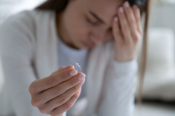 Frustrated young girl holding engagement diamond ring, denying marriage proposal. Stressed unhappy...