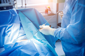 Surgeon performs endoscopic microdiscectomy of herniated intervertebral disc.