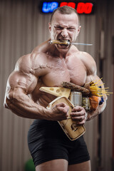 Bodybuilder athlete with food in gym