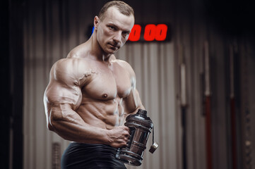 Fototapeta na wymiar Bodybuilder drinking water after fitness workout