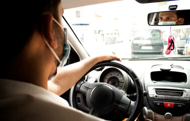 man waiting inside the car with the face mask on