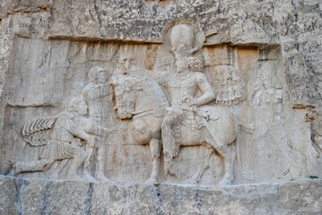 Obraz premium Rock reliefs at Naqsh-e Rustam. Roman Emperor Valerian yields himself to the Persian king Shapur (241-272 AD). Achaemenid and Sassanid periods. UNESCO World Heritage Site. Persepolis Iran.