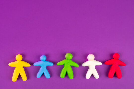 Colorful Little Men On A Lilac Background. The Concept Of Human Diversity With Space For Text. Happy Little People.  Seamless Color Pattern Of Human Figures With Place For Text.